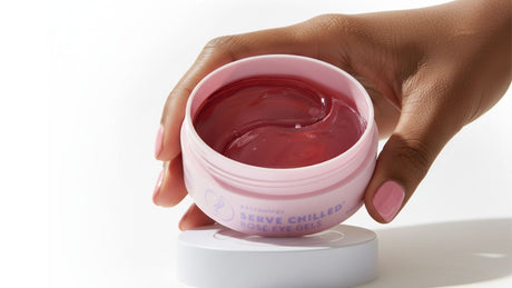 Hand holding a jar of Patchology Serve Chilled Rosé eye gels, showcasing hydrogel patches in a cooling formula designed to refresh and hydrate the under-eye area.