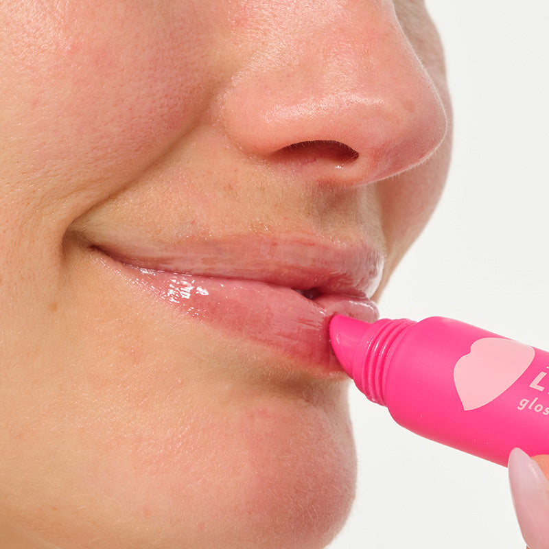 close up in use woman putting on lip service gloss